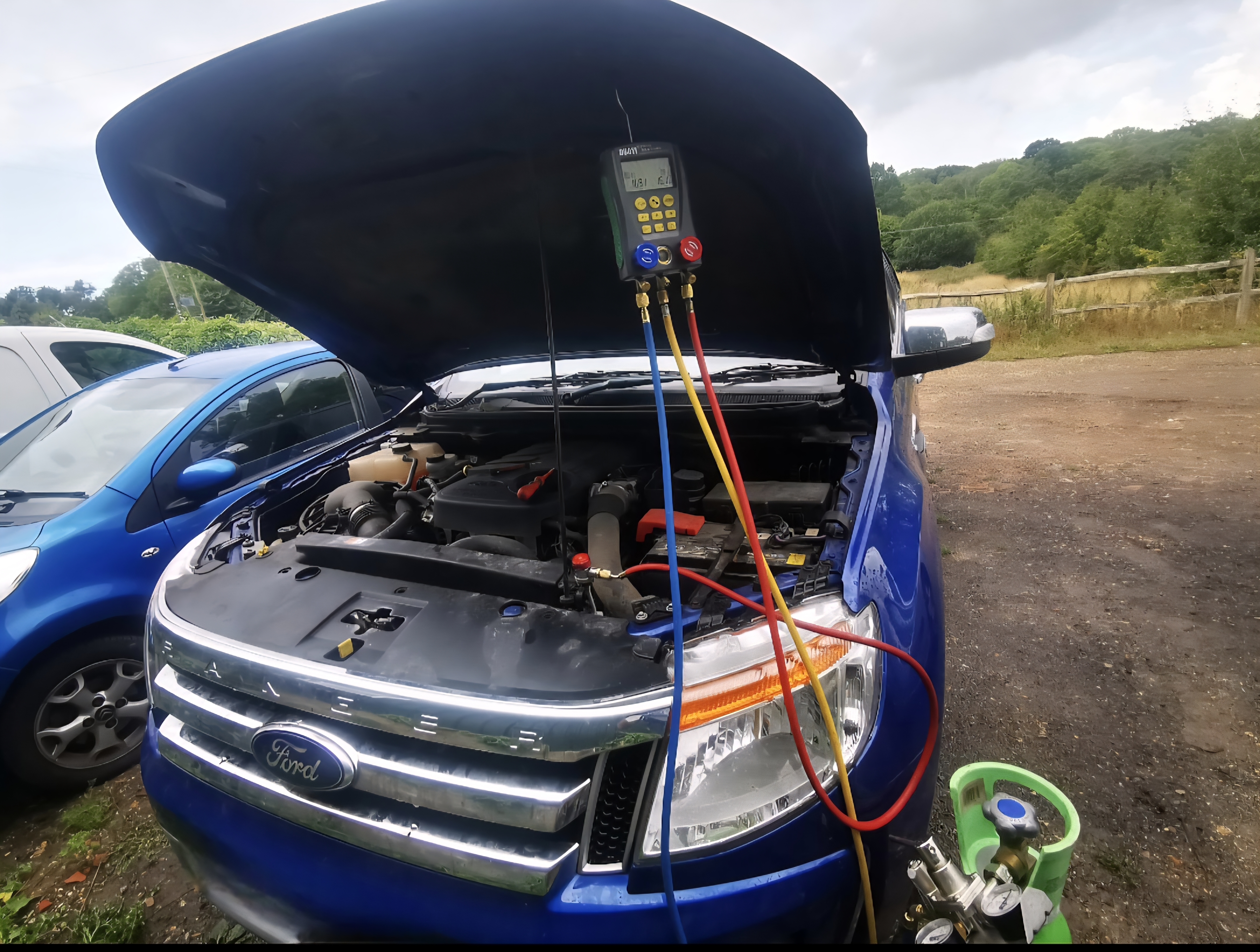Blue Ford Galaxy AC recharge with refrigerant gas bottle